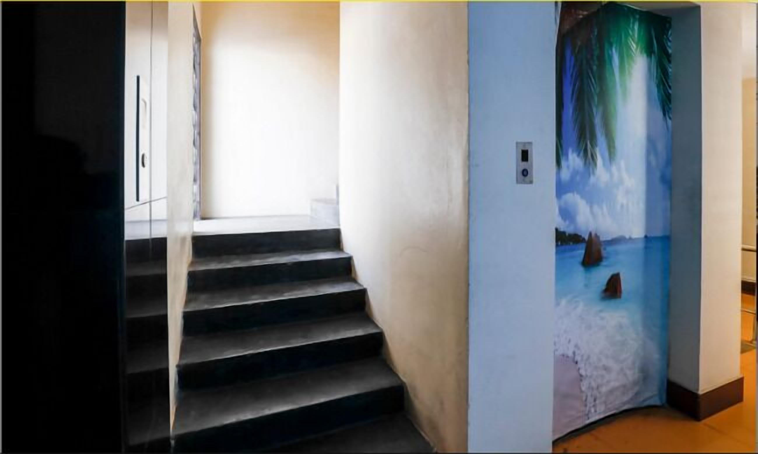A staircase leading to a room with a mural of a beach scene.