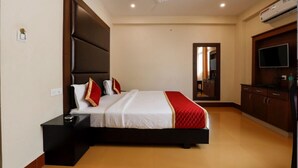 Un dormitorio con una cama grande, una mesita de noche, un aparador y una televisión.