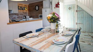 Une table à manger avec des assiettes, des verres et un vase de fleurs.