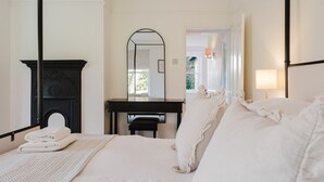 Una camera da letto con un letto, una scrivania, uno specchio e una finestra.