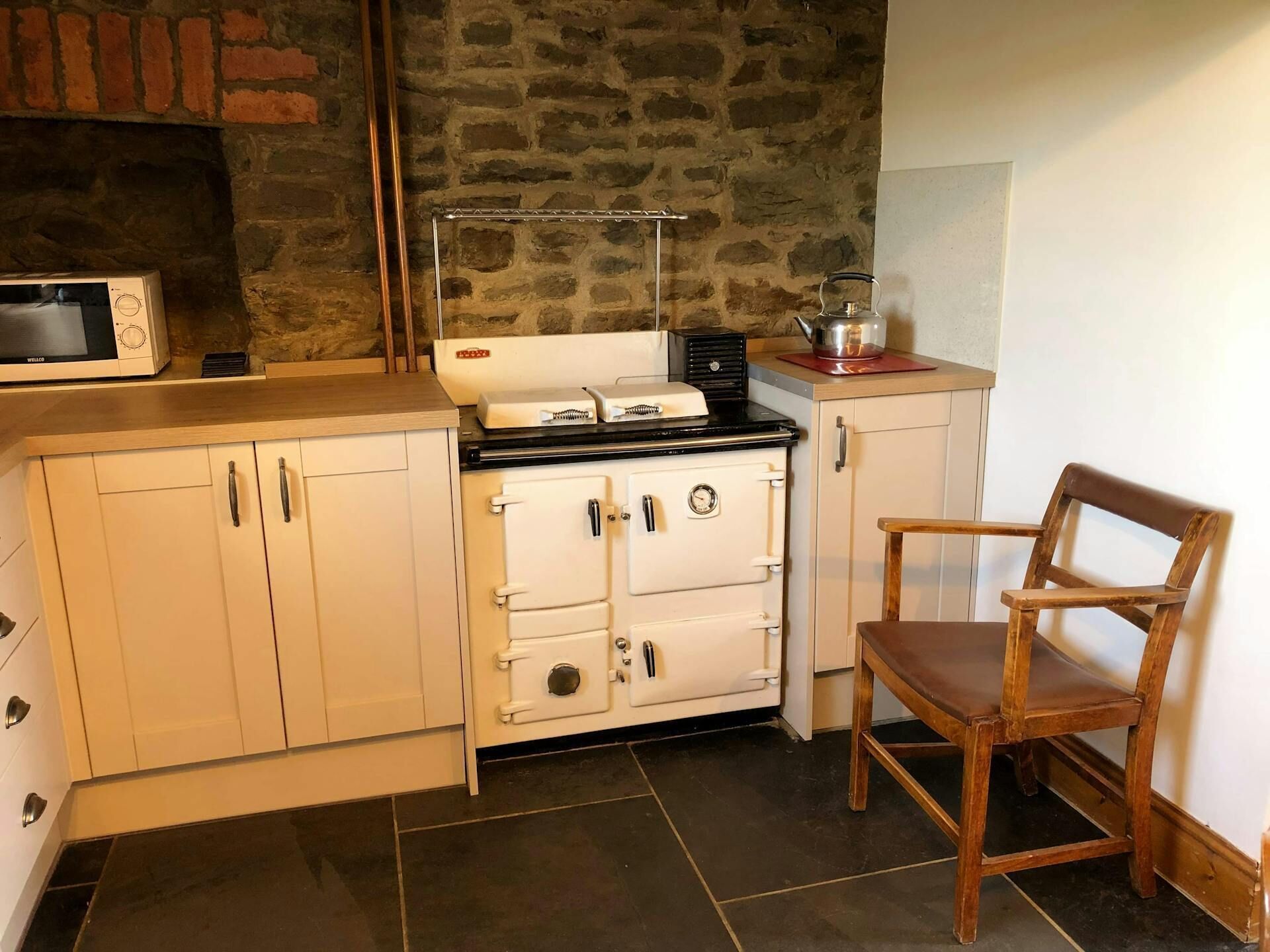 A kitchen with a stove, microwave, and cabinets.