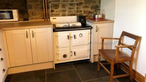 Una cocina equipada con estufa, microondas y armarios.