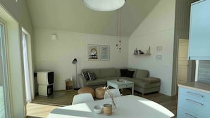 A modern living room with a white sofa, a dining table with chairs, and a hanging light fixture.