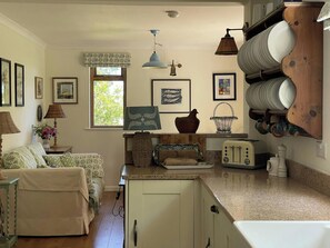 A kitchen with a wooden cabinet, a window, a lamp, and a toaster. - Castle Reach, Newport (Newport)