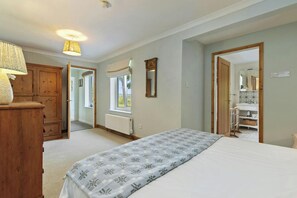 Ein Schlafzimmer mit einem Bett, einem Holzschrank, einer Heizung und einem Fenster mit Vorhängen.