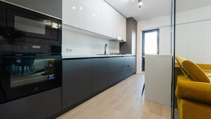 Une cuisine moderne dotée d’un four encastré, d’un four à micro-ondes et d’un grand îlot central avec un évier.