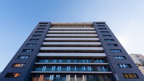 Un immeuble moderne de grande hauteur, doté de nombreux étages, de grandes fenêtres et d’une façade plane.