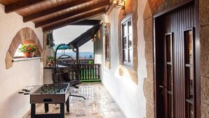 A cozy outdoor patio with a foosball table, stone flooring, wooden beams, and a view of the sea. - San Vinogradara - One Bedroom Holiday Home With Hot Tube (Donja Stubica)