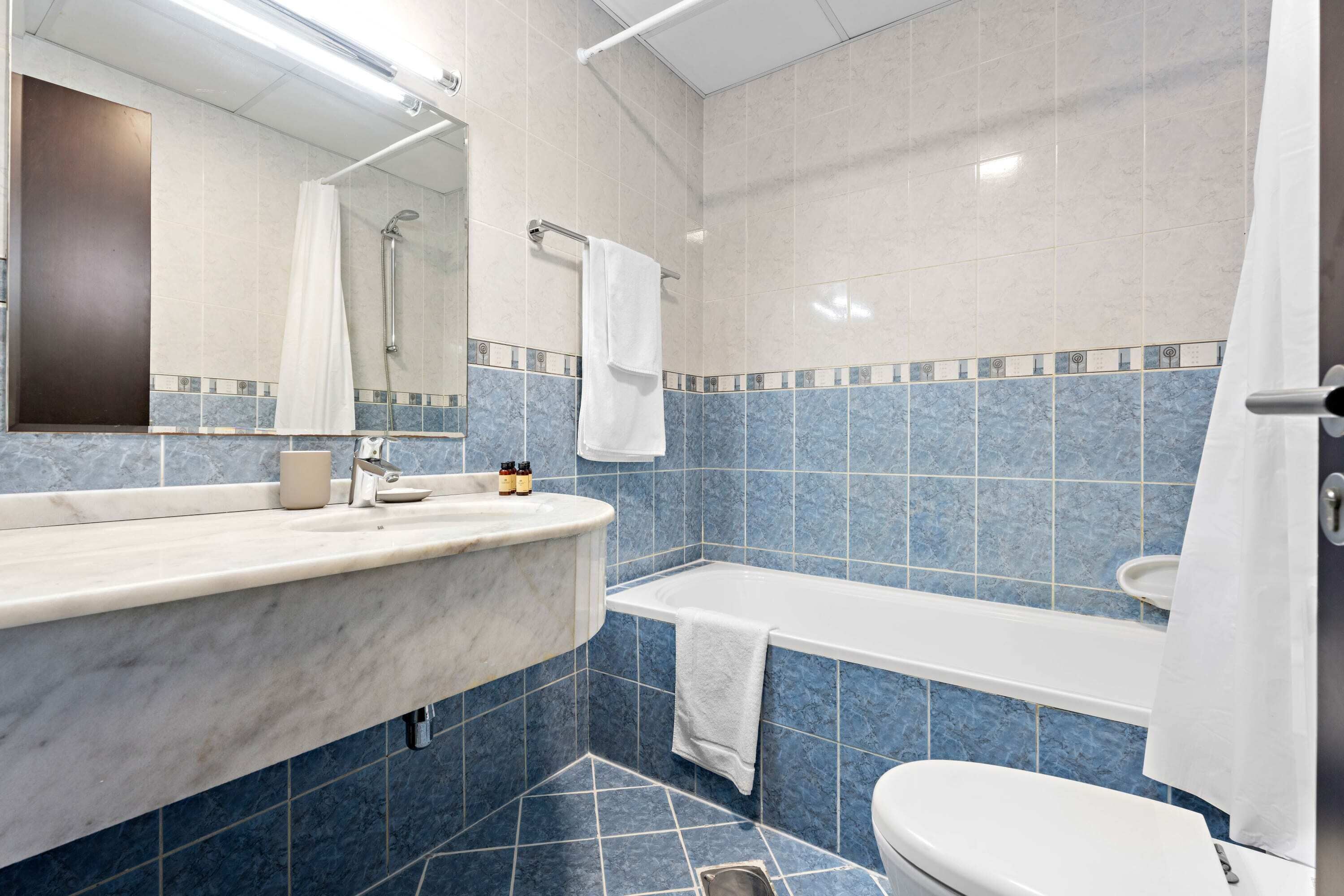 Une salle de bain moderne avec un lavabo en marbre, une baignoire et des toilettes.