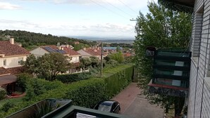 A residential area with houses, a swimming pool, and a view of a distant landscape.
