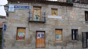 A stone building with a sign reading "FRESNEDILLAS" and numbered windows.
