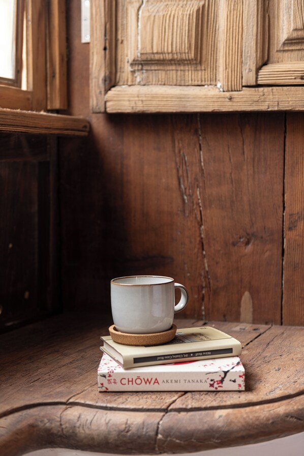 A wooden table with a cup and books. - Hotel Emblemático La Casa De La Camelia (San Cristóbal de La Laguna)