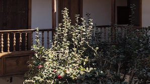 Ein traditionelles Gebäude mit Ziegeldach, Holztüren und einem Balkon mit Geländer.