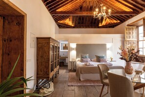 A bedroom with a wooden ceiling, a bed with pillows, a bedside table, and a window. - Hotel Emblemático La Casa De La Camelia (San Cristóbal de La Laguna)