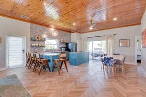 Enjoy meals in this kitchen with a central island, dining table for six, and large window offering a view of the outdoors.
