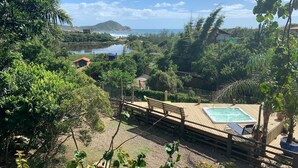 A wooden deck with a hot tub and a view of a lake and mountains. - Cabanas Rosa Mistica (Imbituba)
