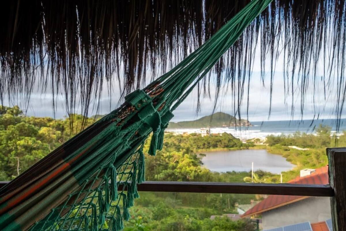A hammock with a view of a lake, greenery, and a distant island.