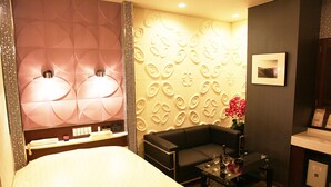 A hotel room with a bed, a sofa, a small table with glasses, and a decorative wall. - HOTEL Let's (Saitama)