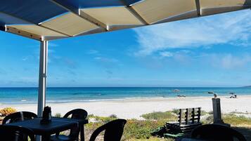 Ein Sitzbereich im Freien mit Blick auf Strand und Meer.