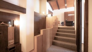 A staircase leading to a second floor with wooden walls and a ceiling light. - Casa Viva (Bad Ragaz)