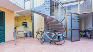 Un escalier en colimaçon dans un immeuble, avec des vélos garés à proximité.