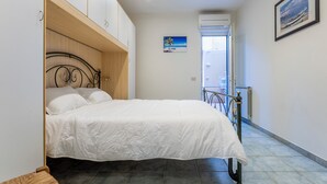 Une chambre à coucher avec un lit, une armoire en bois et un tableau accroché au mur.