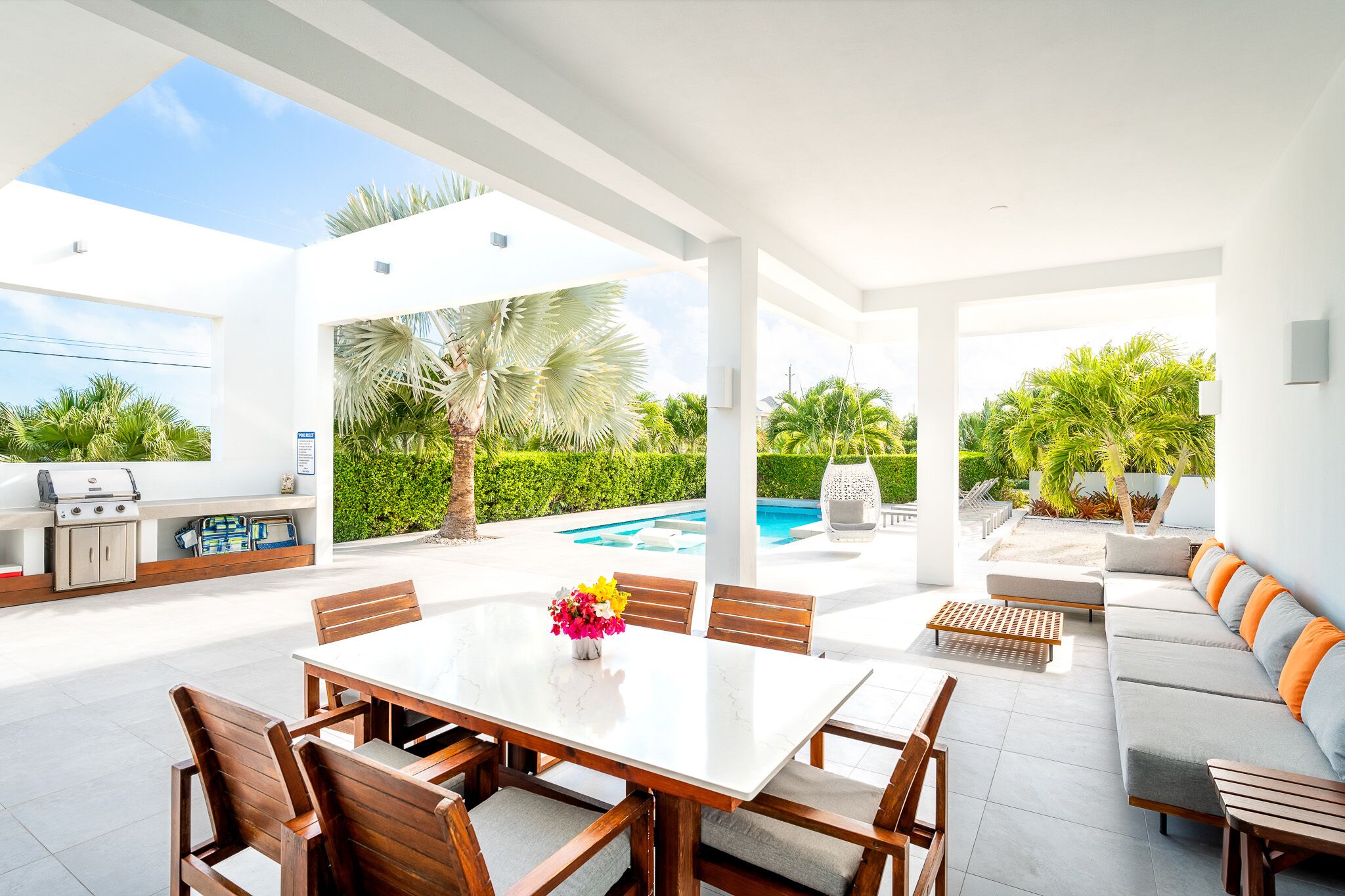 Un espace extérieur aménagé pour les repas, avec une piscine, un barbecue et un coin salon.