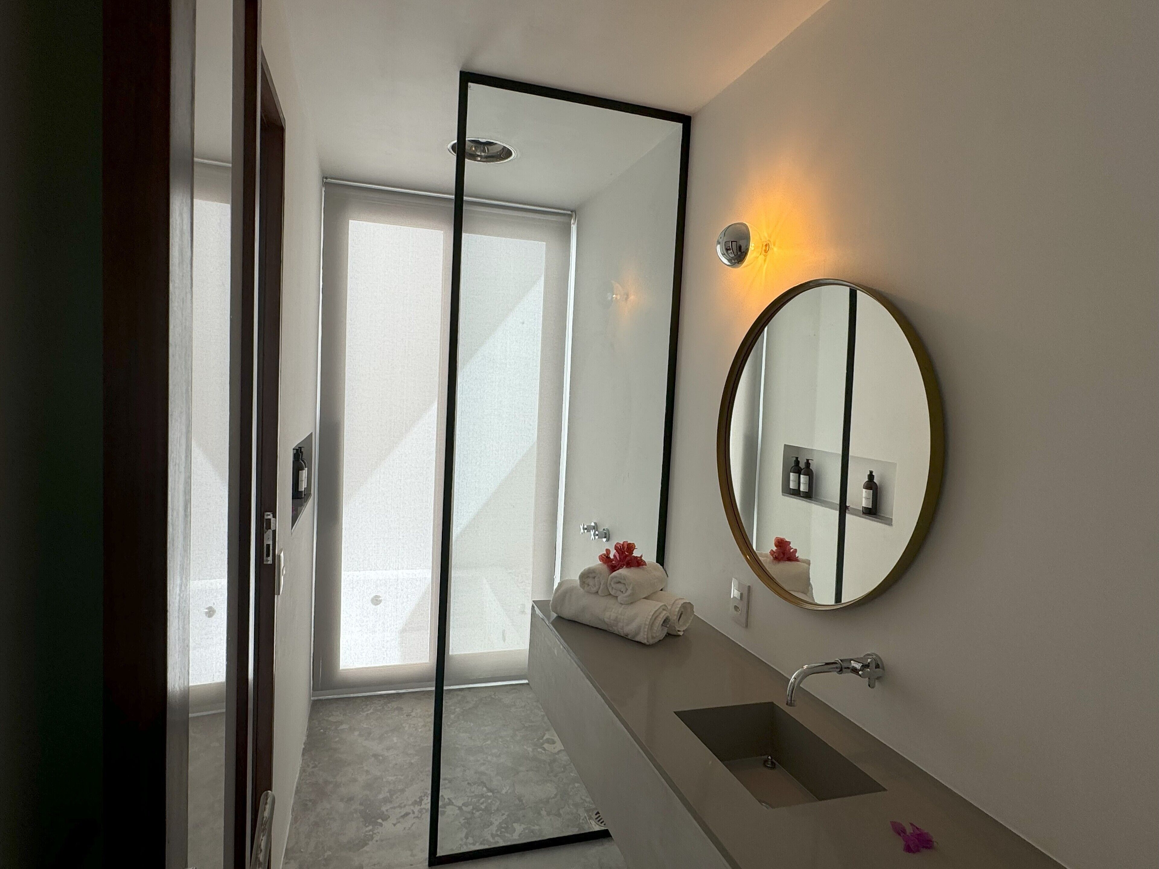 A modern bathroom with a large mirror, a sink, and a towel rack.