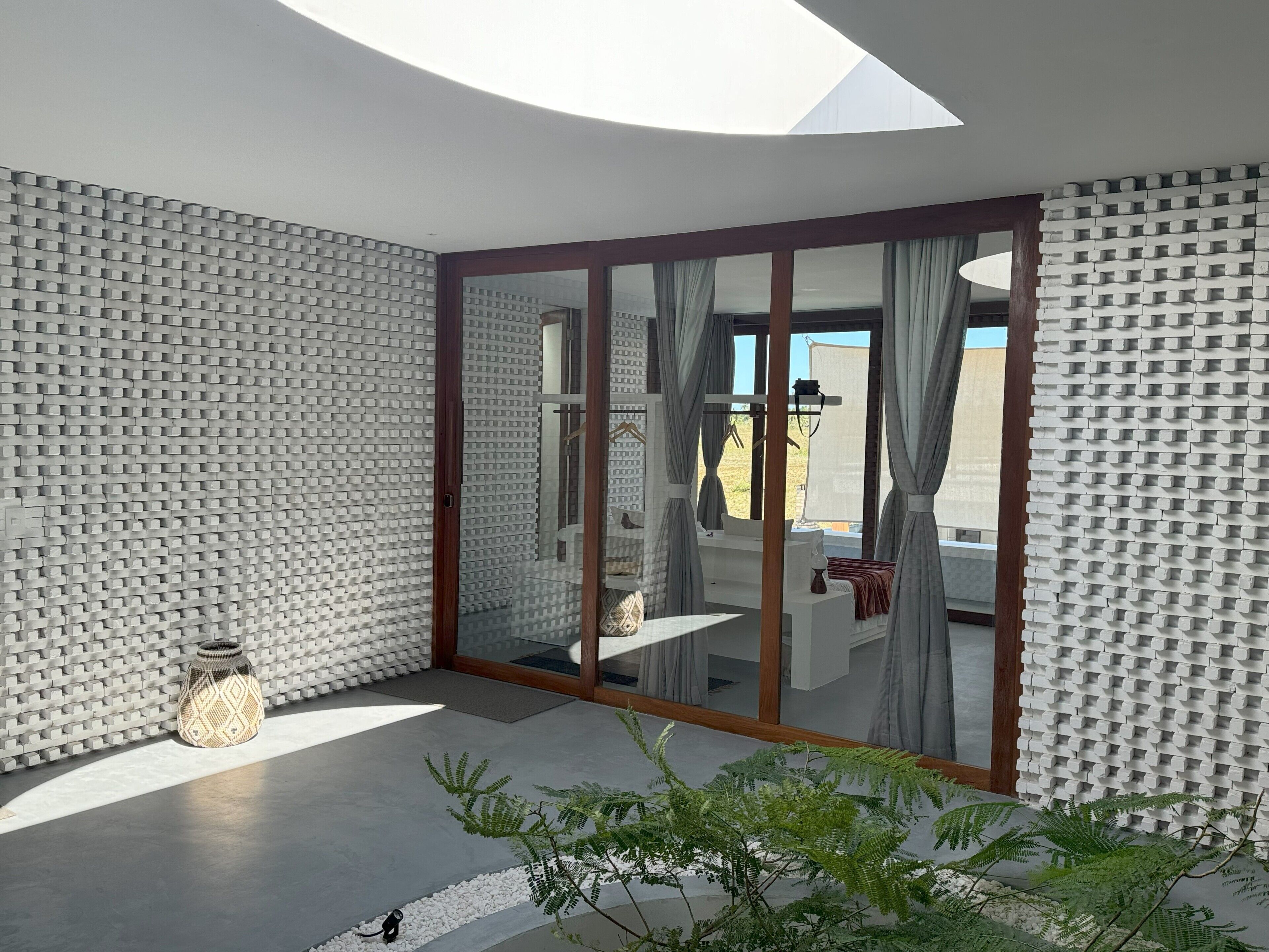 Een moderne kamer met dakraam, een grote schuifpui en een kamer met een patroon op de muur.