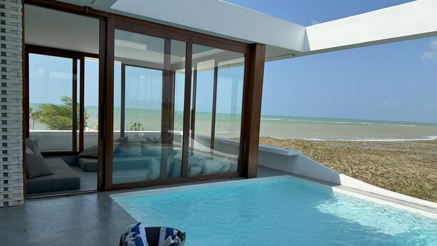 A modern infinity pool with a clear view of the beach and ocean.