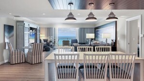 A modern hotel room with a dining area, a large window with a view of the ocean, and a ceiling with a skylight. - 2/2 Beachfront, VIEWS, Pool, Private Beach Access (Longboat Key)