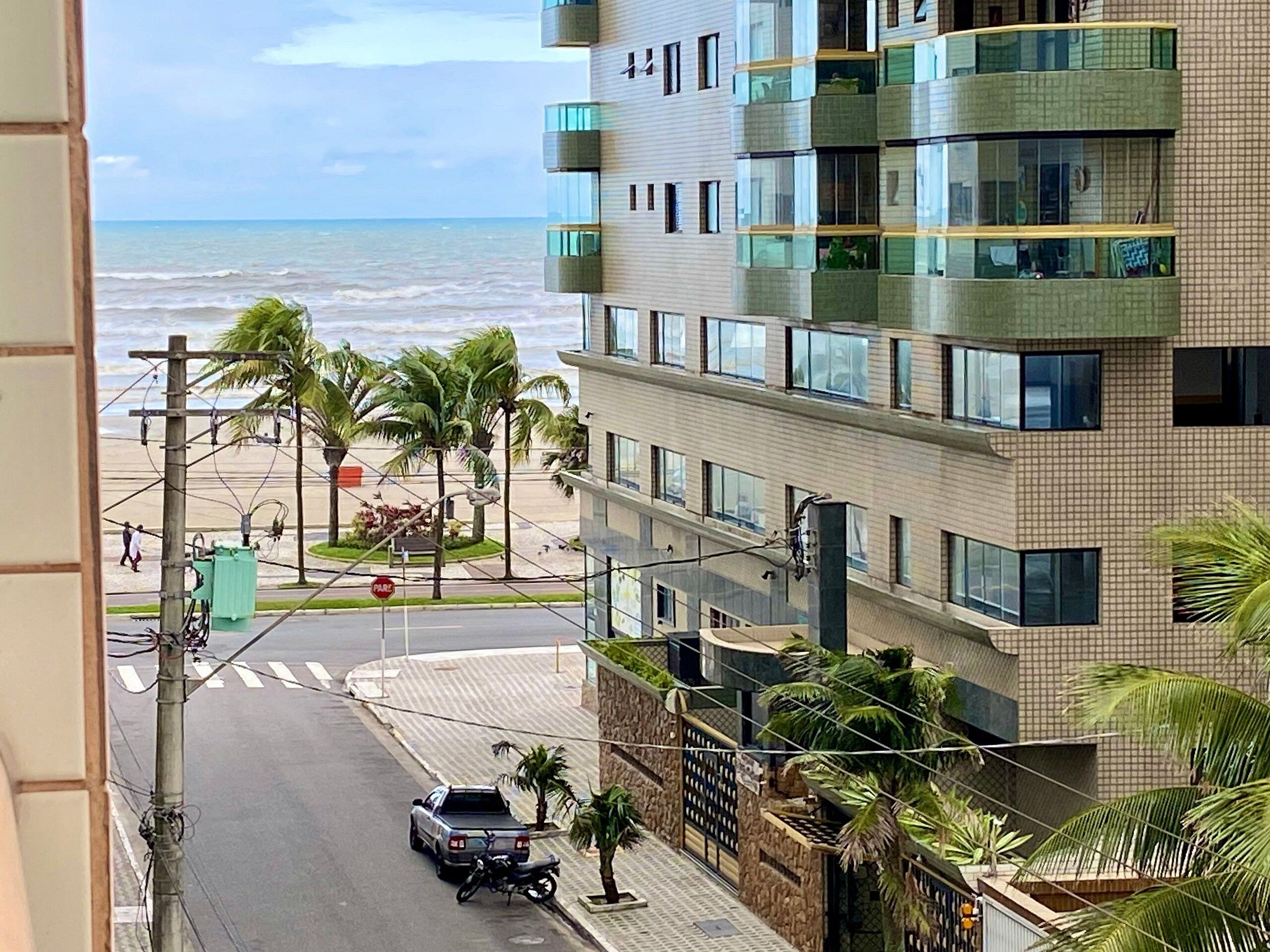 A multi-story building with balconies overlooking a beach.