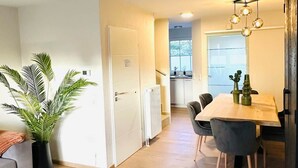 Een moderne keuken met een eethoek, een potplant en uitzicht door het raam.