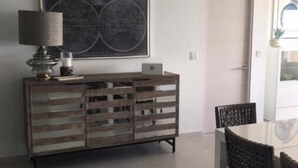 A dining area with a wooden cabinet, a table, and chairs. - Luxury Suite 2.4 in Seneca, Point Blanche, St Maarten (Point Blanche)