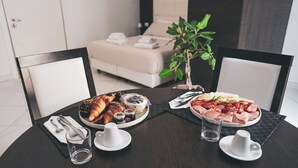 A dining table with plates of food, cutlery, and glasses.