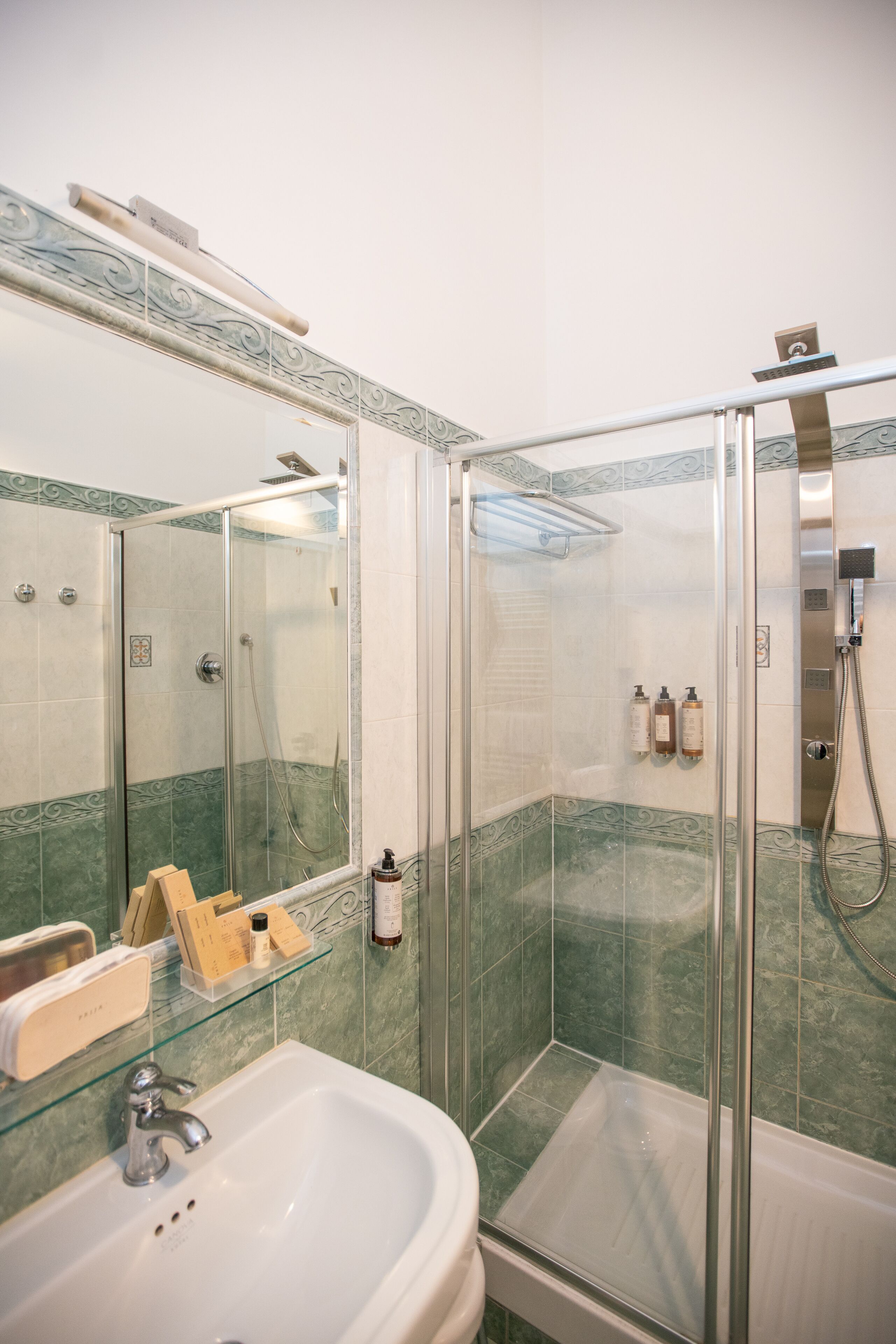 Ein Badezimmer mit Duschkabine, Waschbecken und Spiegel.