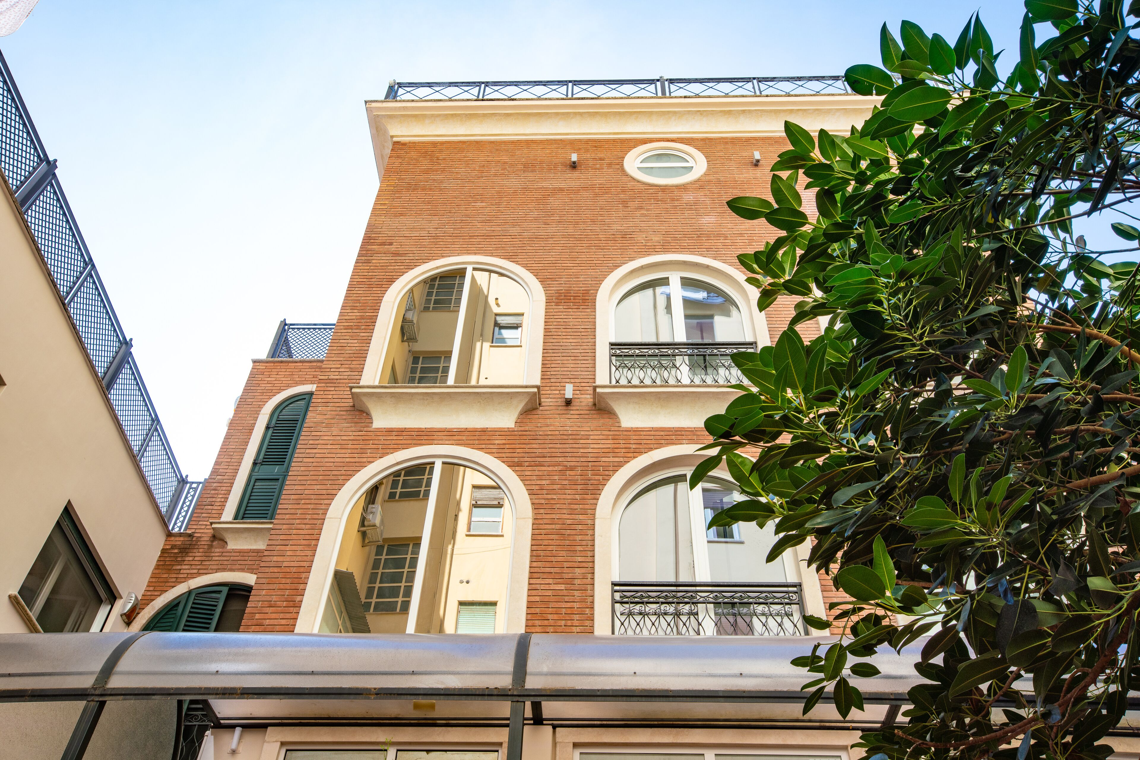 A multi-story building with arched windows and a balcony.