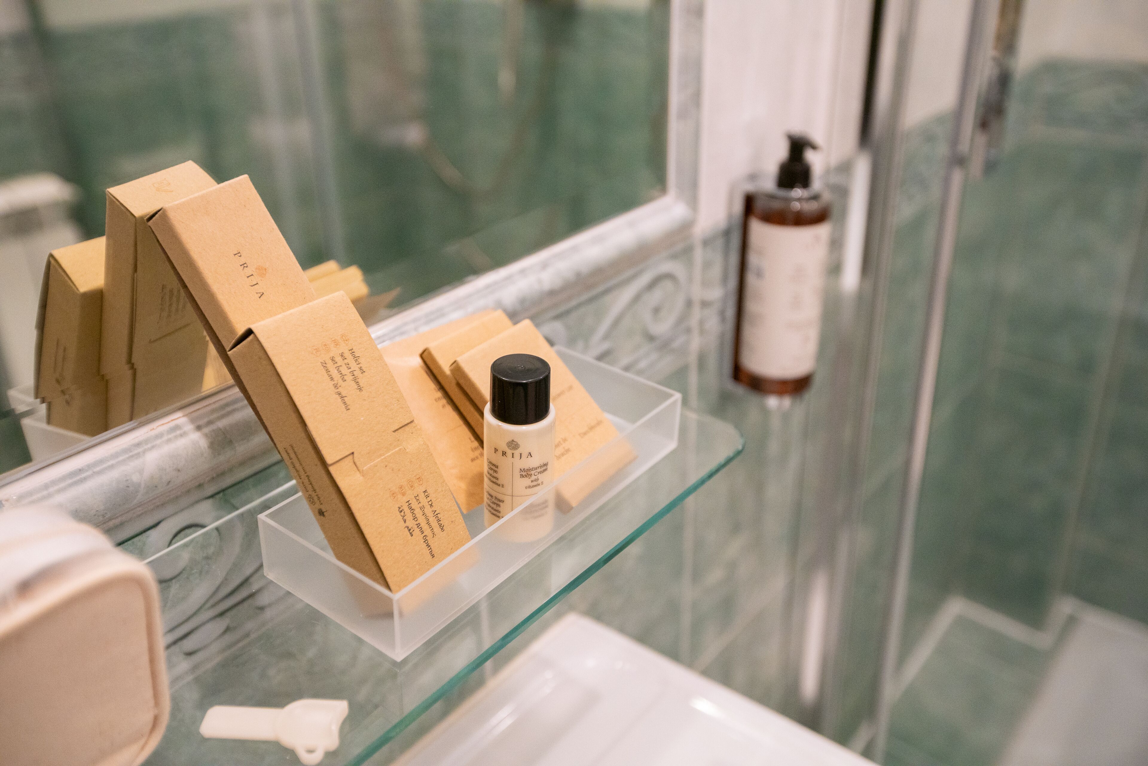 A bathroom with a glass shelf displaying toiletries and a key.