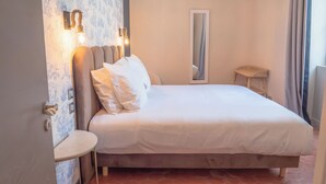 A neatly made bed with white linens and a headboard with wall-mounted lights. - Le Pavillon, Appartement Écolodge Haut de Gamme Avec Piscine et Jacuzzi (Pézenas)