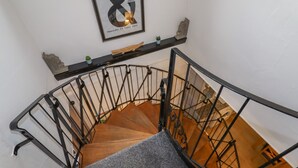 A spiral staircase with a black metal railing and wooden steps.