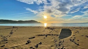 Una platja amb empremtes i una passera de fusta.