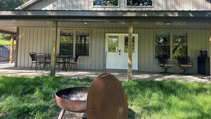 A covered outdoor area with a metal fire pit, a wooden post, and a table with chairs. - Nature's Retreat: Ultimate ATV & Fishing Getaway minutes from Cherry Springs (Galeton)