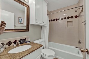 Une salle de bain avec un lavabo, des toilettes et une douche.