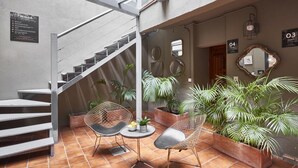 A modern interior with a staircase, seating area, and potted plants. - BeBarceloner Gothic Quarter Studios (Barcelona)