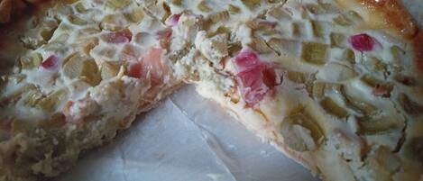 A close-up of a pizza with various toppings, including cheese, vegetables, and possibly meat.