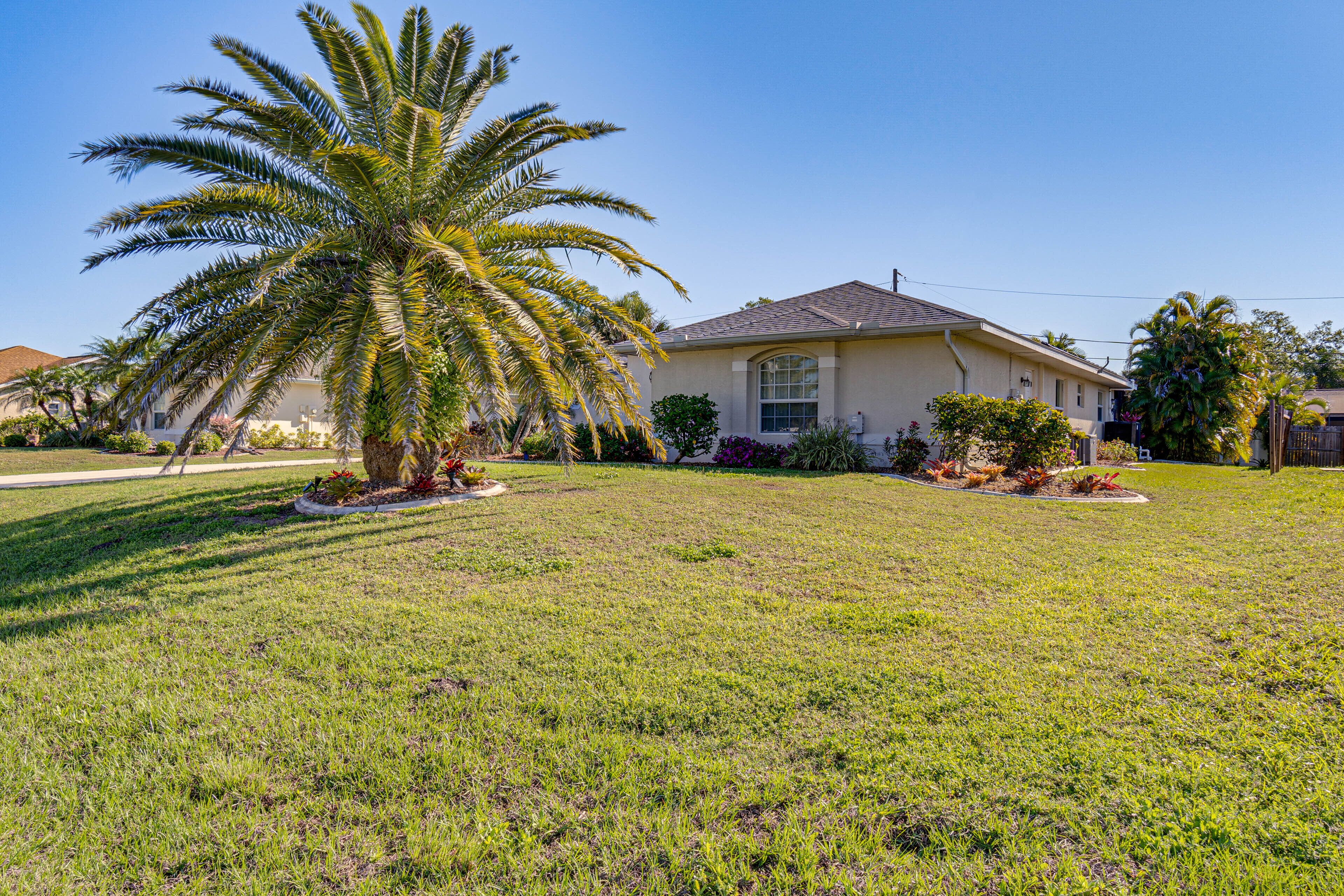A single-story house with a well-maintained lawn and a palm tree in the front yard.