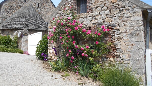 A stone building with a white door and a window. - Gîte 5 Personnes (Le Vast)