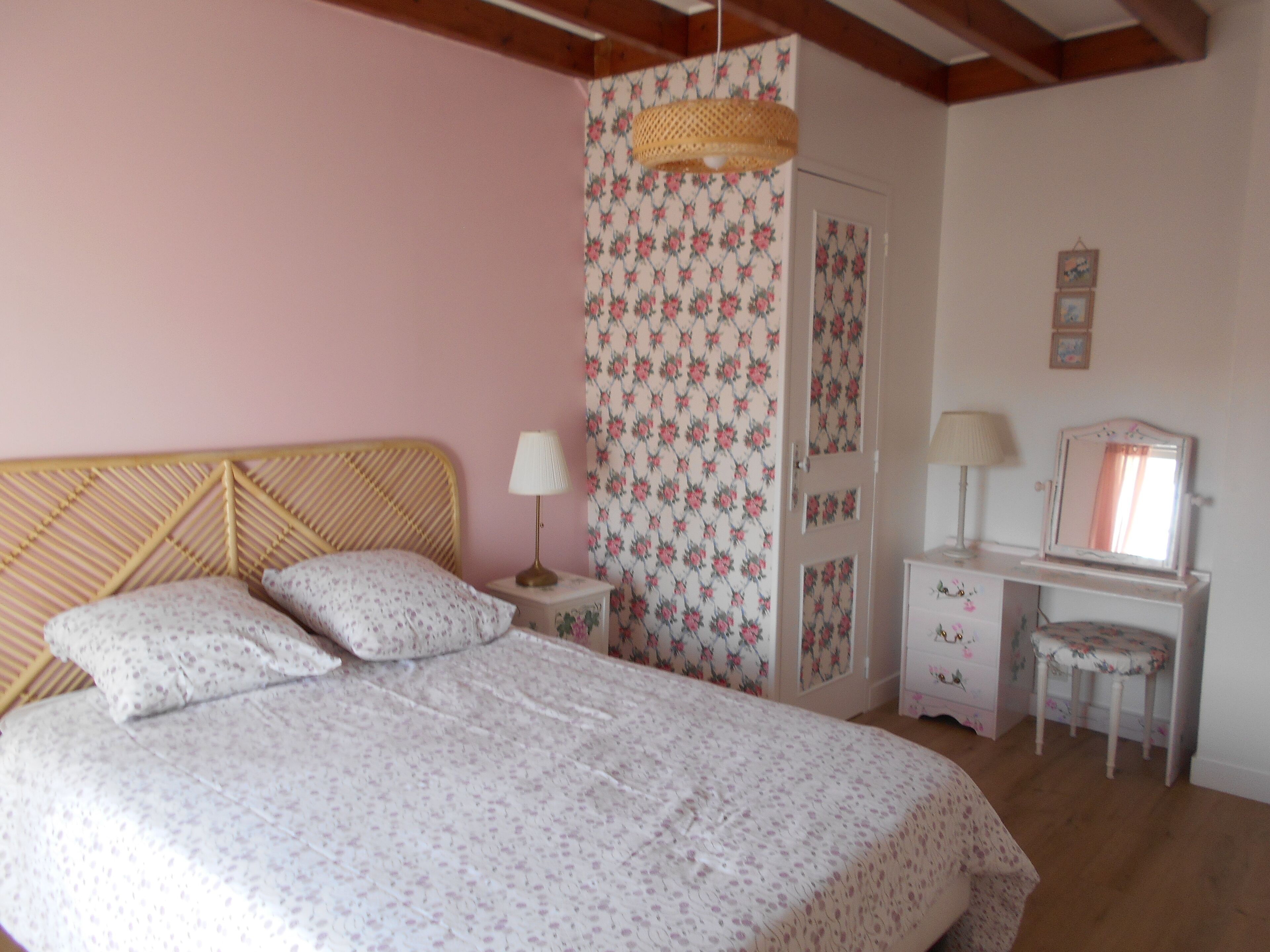 A bedroom with a bed, a nightstand, a dresser, a mirror, and a chair.