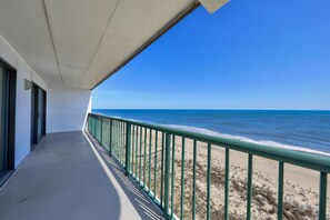 Ein Balkon mit Blick auf Strand und Meer.