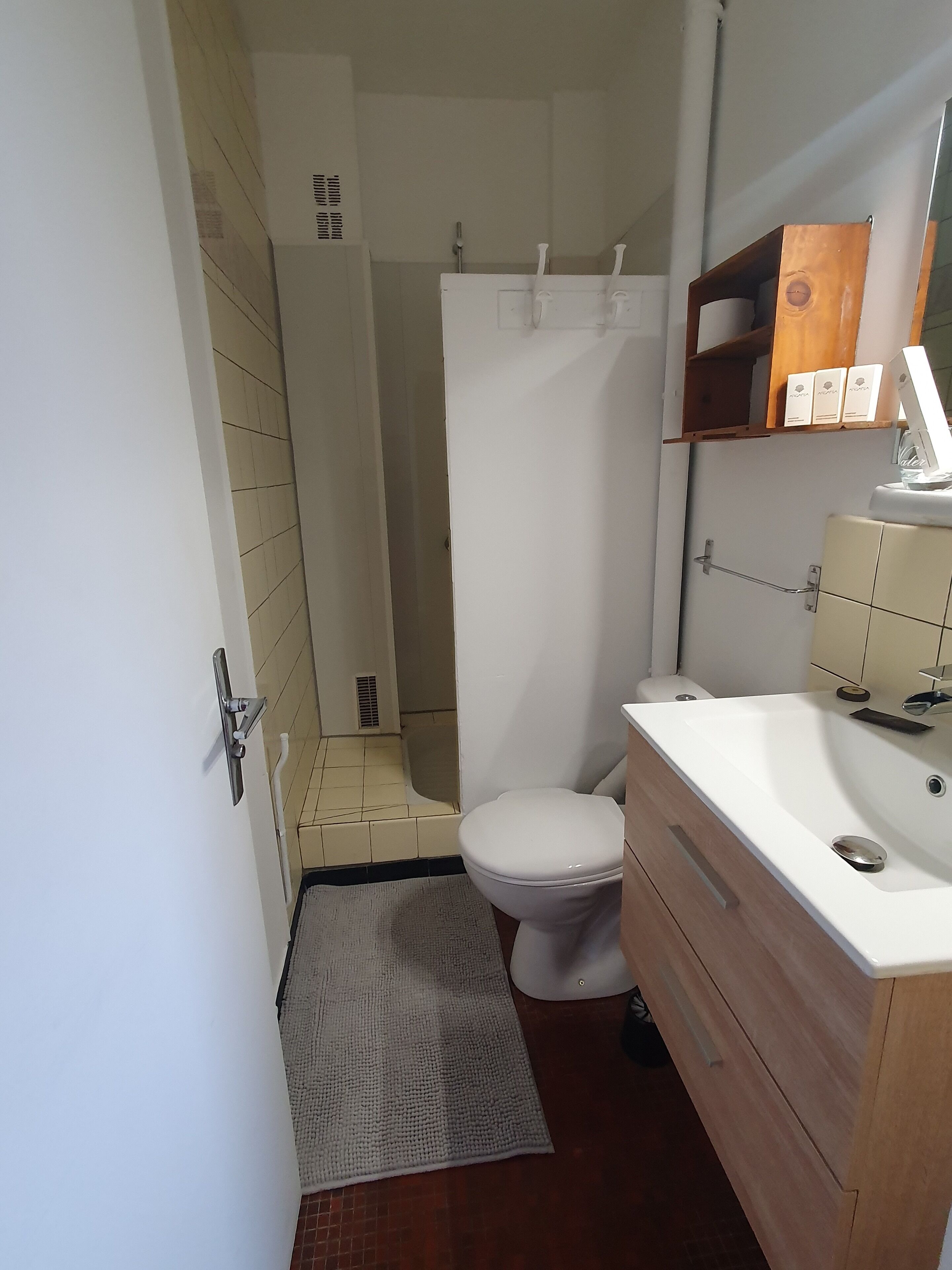 Une petite salle de bain comprenant des toilettes, un lavabo et un espace douche.
